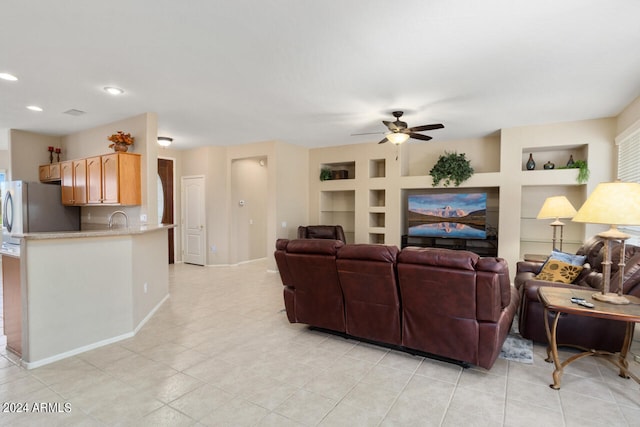 living room with built in shelves, light tile patterned floors, and ceiling fan