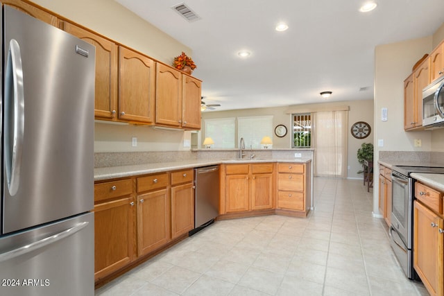 kitchen featuring appliances with stainless steel finishes, kitchen peninsula, sink, and ceiling fan