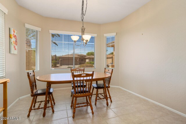 tiled dining area featuring a chandelier and a healthy amount of sunlight