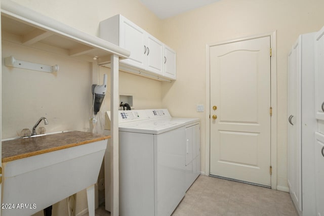 washroom featuring cabinets, sink, and independent washer and dryer