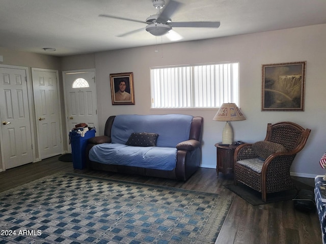 living room featuring dark wood-type flooring and ceiling fan