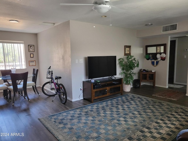 living room with baseboards, wood finished floors, visible vents, and a ceiling fan