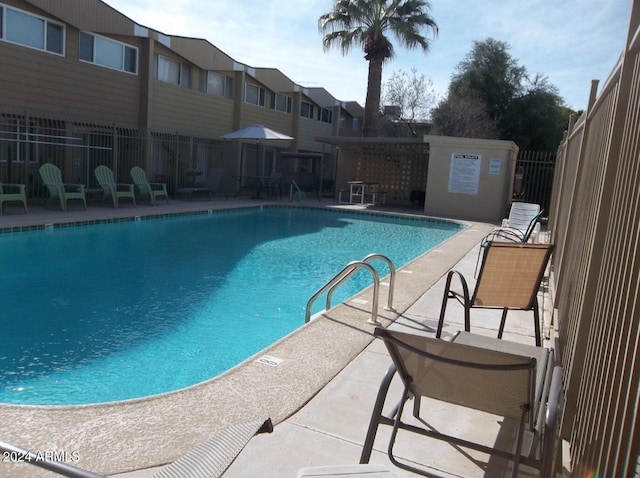 community pool featuring fence and a patio