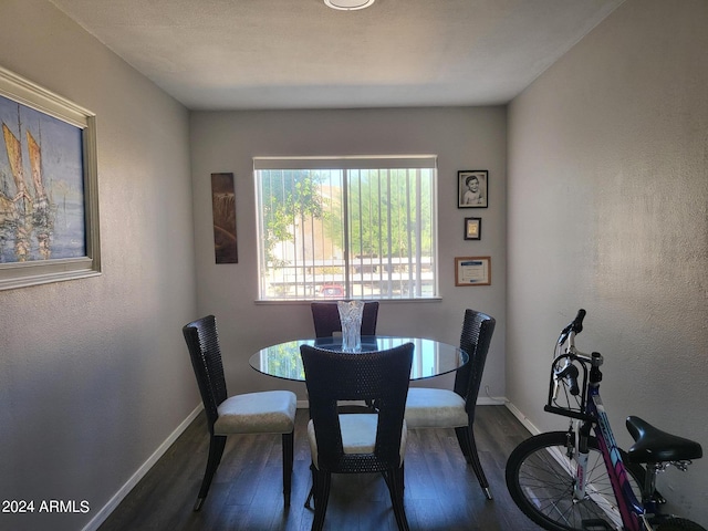dining space featuring dark wood finished floors and baseboards