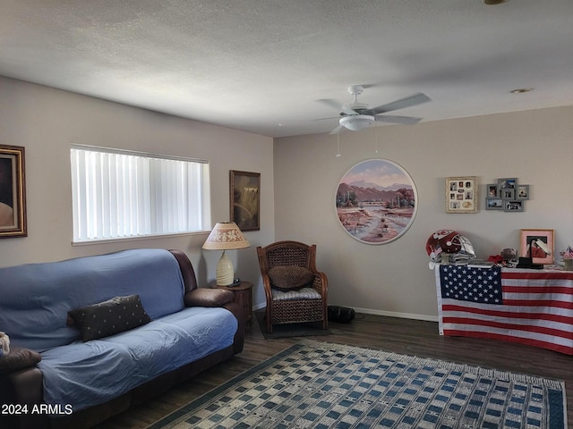 living room with ceiling fan, a textured ceiling, and dark hardwood / wood-style floors