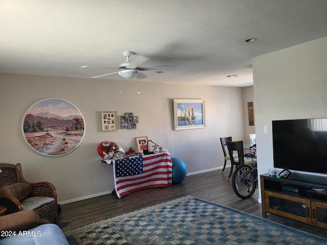 living room featuring ceiling fan and dark hardwood / wood-style floors