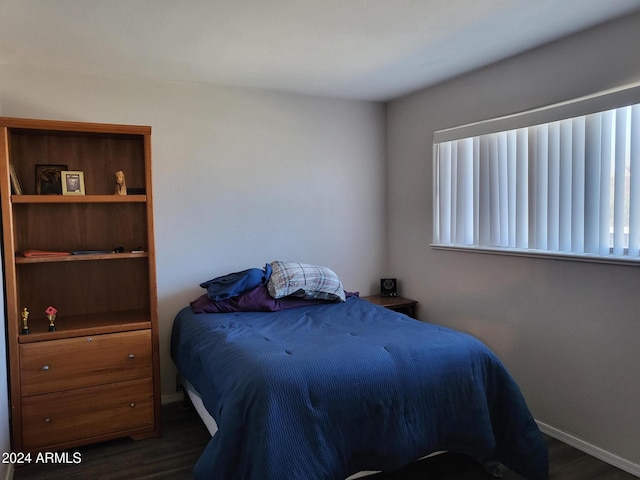 bedroom with dark wood-type flooring, baseboards, and multiple windows