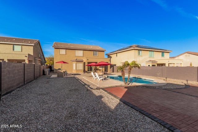 back of house with a patio, solar panels, and a fenced in pool