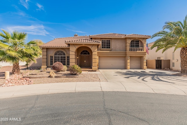 mediterranean / spanish home with a tile roof, concrete driveway, a garage, and stucco siding