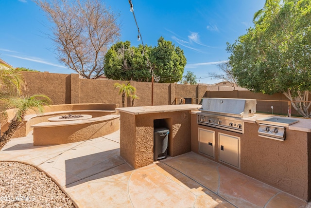 5917 N 133rd Ave, Litchfield Park, AZ 85340 - view of patio featuring area for grilling, a fire pit, exterior kitchen, and a fenced backyard