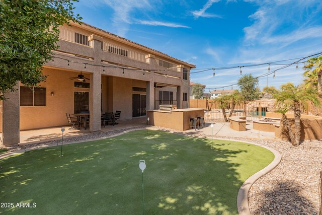 5917 N 133rd Ave, Litchfield Park, AZ 85340 - rear view of house with fence, stucco siding, a fire pit, a patio area, and outdoor dry bar