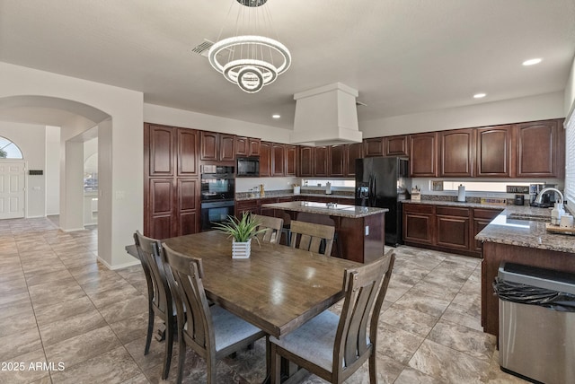 5917 N 133rd Ave, Litchfield Park, AZ 85340 - kitchen with premium range hood, visible vents, black appliances, a sink, and arched walkways