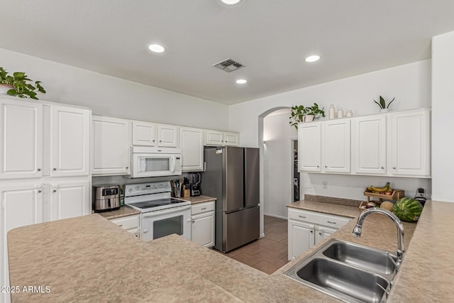 609 S 122nd Dr, Avondale, AZ 85323 - kitchen with white appliances, arched walkways, white cabinetry, light countertops, and recessed lighting