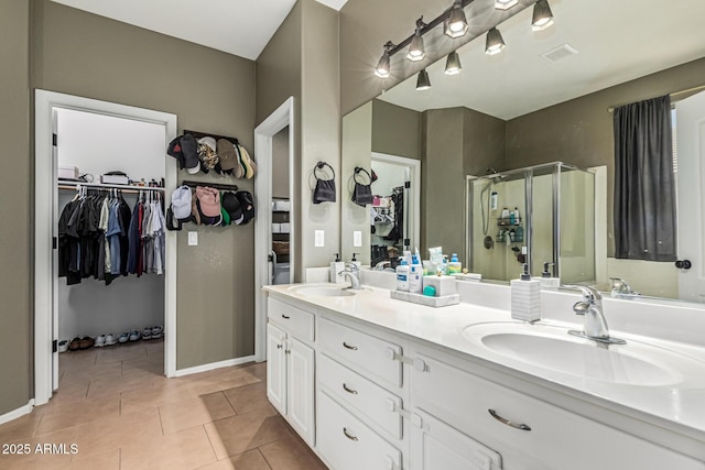 609 S 122nd Dr, Avondale, AZ 85323 - full bath featuring a stall shower, double vanity, a walk in closet, and tile patterned flooring