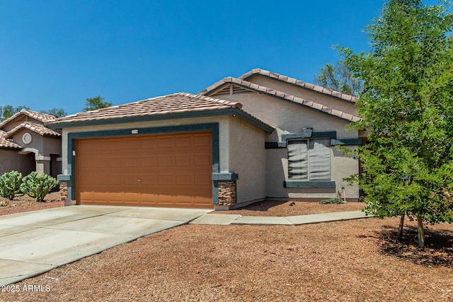 14936 W Maui Ln, Surprise, AZ 85379 - view of front facade featuring stucco siding, an attached garage, a tiled roof, and concrete driveway