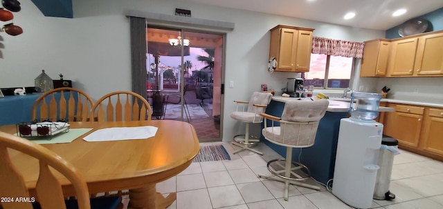 kitchen featuring light brown cabinets, light tile patterned flooring, hanging light fixtures, and an inviting chandelier