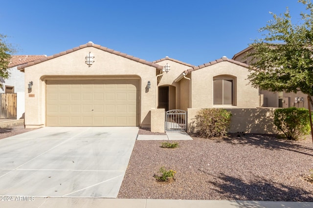 19034 W Yucatan Dr, Surprise, AZ 85388 - mediterranean / spanish-style house featuring driveway, a garage, a tiled roof, stucco siding, and a gate