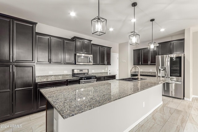 19034 W Yucatan Dr, Surprise, AZ 85388 - kitchen with stainless steel appliances, a sink, dark stone countertops, a kitchen island with sink, and hanging light fixtures