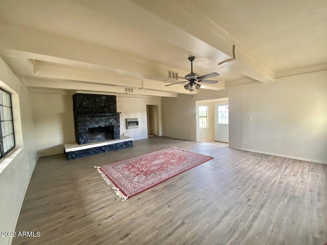 unfurnished living room featuring beam ceiling, a fireplace, ceiling fan, and hardwood / wood-style floors