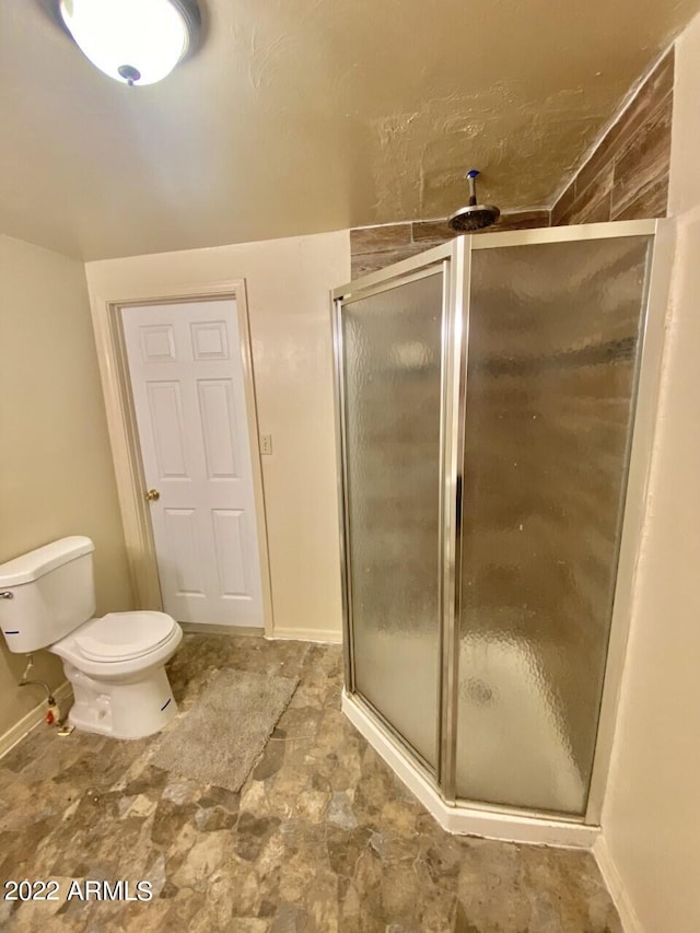 bathroom with a shower with shower door, toilet, and tile floors