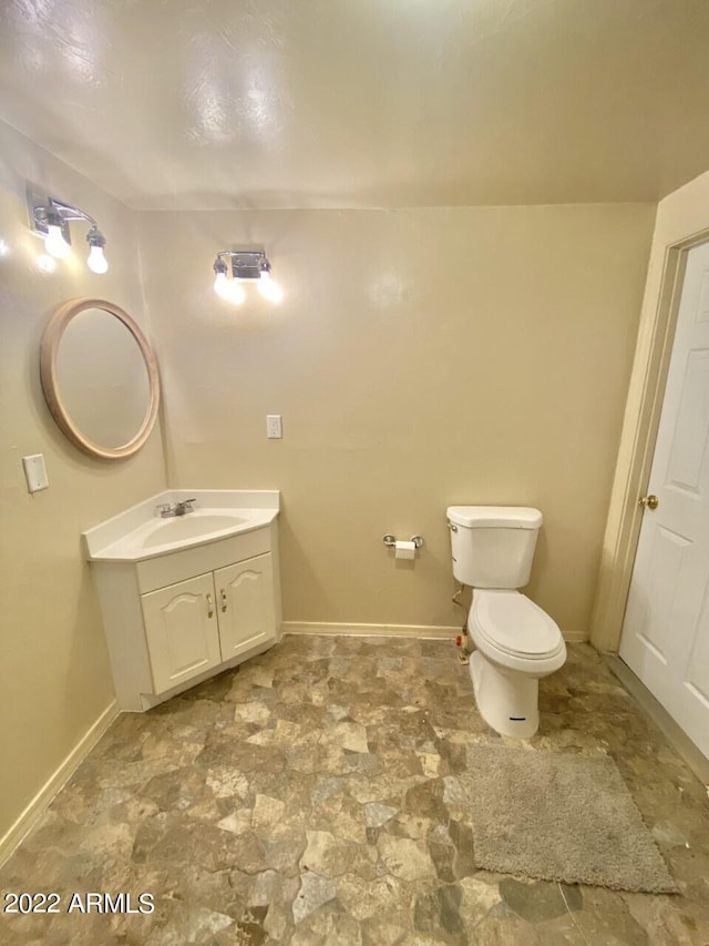 bathroom featuring tile flooring, vanity, and toilet