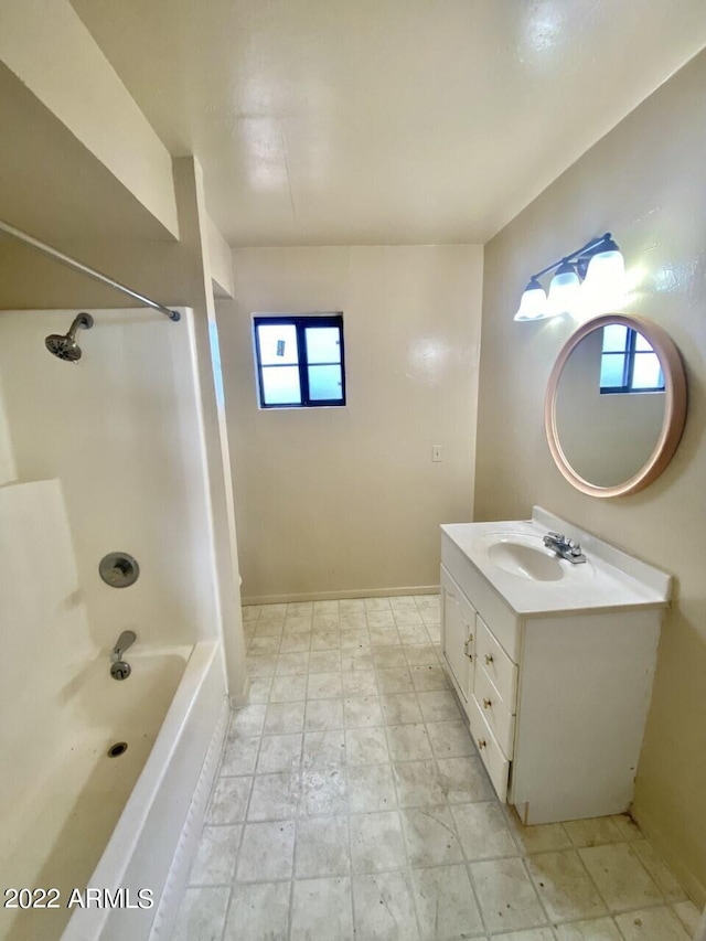 bathroom with tile floors,  shower combination, a wealth of natural light, and vanity