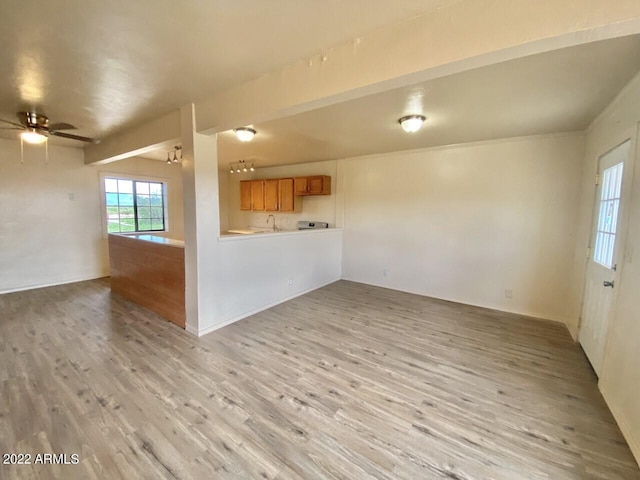 unfurnished living room with a ceiling fan and light wood-style flooring