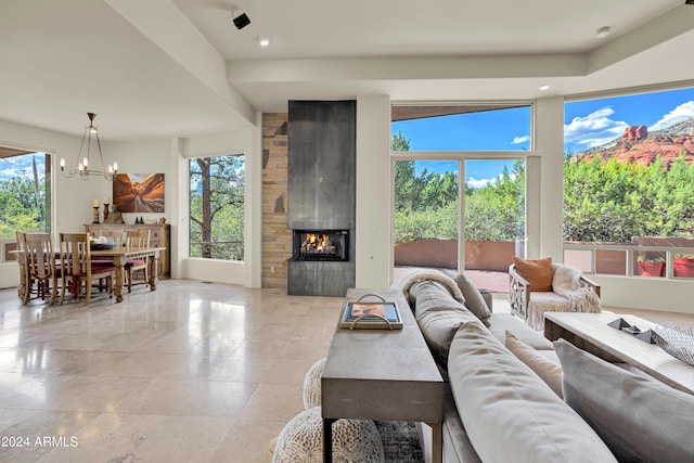 living area featuring recessed lighting, a large fireplace, an inviting chandelier, and a healthy amount of sunlight