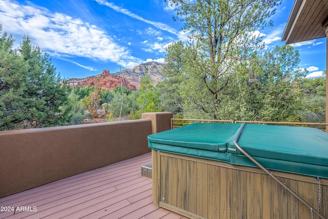 wooden deck featuring a mountain view and a hot tub