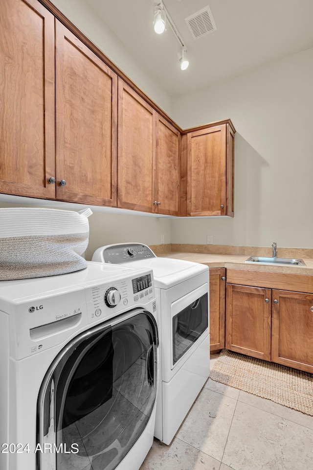 laundry area featuring visible vents, cabinet space, washer and clothes dryer, and a sink