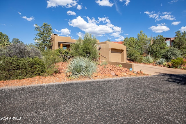 view of front of property with a garage, stucco siding, and concrete driveway