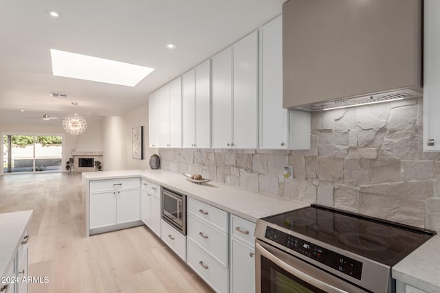 kitchen featuring backsplash, white cabinetry, light hardwood / wood-style flooring, and appliances with stainless steel finishes