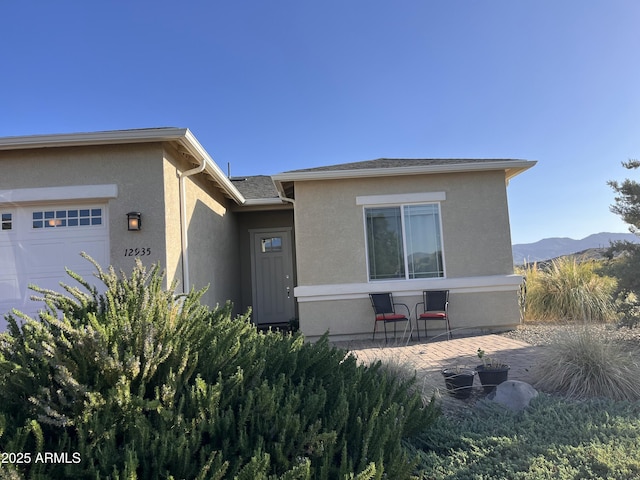 12935 E Ramos St, Dewey, AZ 86327 - view of front of home with a garage, stucco siding, and a mountain view