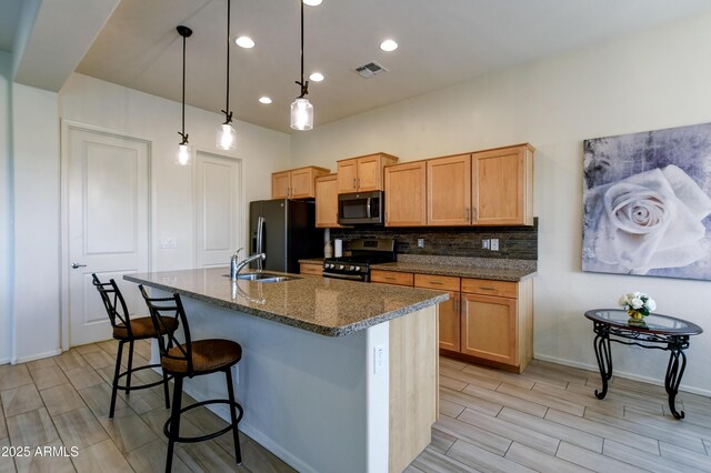 12935 E Ramos St, Dewey, AZ 86327 - kitchen featuring stainless steel appliances, a breakfast bar, tasteful backsplash, a sink, and a kitchen island with sink