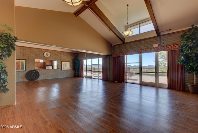 12935 E Ramos St, Dewey, AZ 86327 - unfurnished living room featuring high vaulted ceiling, brick wall, beamed ceiling, and wood finished floors