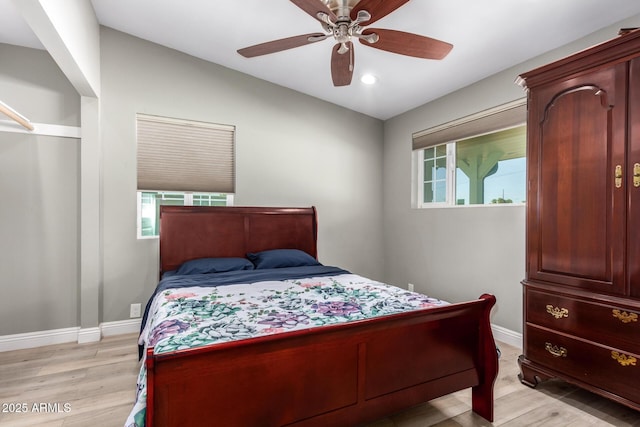 bedroom with ceiling fan, vaulted ceiling, and light wood-type flooring