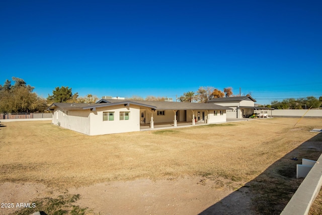 rear view of house featuring a lawn