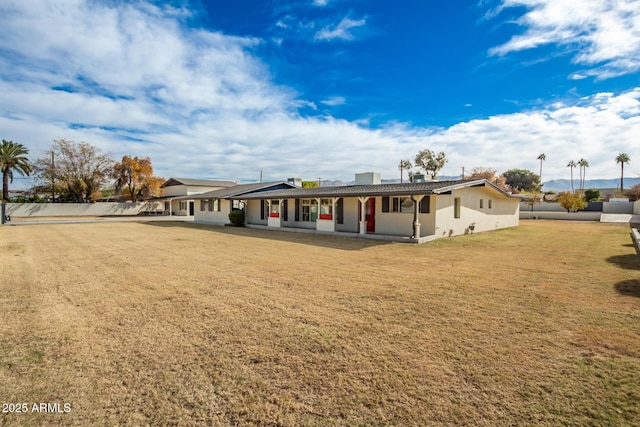 rear view of house featuring a lawn