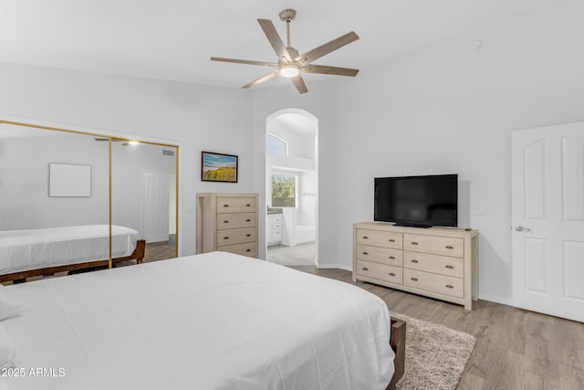 4301 E Abraham Ln, Phoenix, AZ 85050 - bedroom with arched walkways, high vaulted ceiling, wood finished floors, a closet, and a ceiling fan