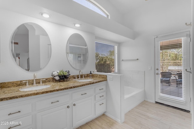 4301 E Abraham Ln, Phoenix, AZ 85050 - full bath featuring double vanity, plenty of natural light, a garden tub, and wood finished floors