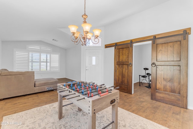 4301 E Abraham Ln, Phoenix, AZ 85050 - recreation room with vaulted ceiling, wood finished floors, a barn door, and a chandelier