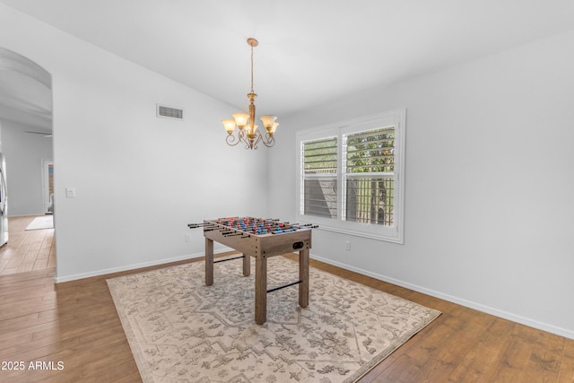 4301 E Abraham Ln, Phoenix, AZ 85050 - game room featuring wood finished floors, arched walkways, lofted ceiling, and a chandelier