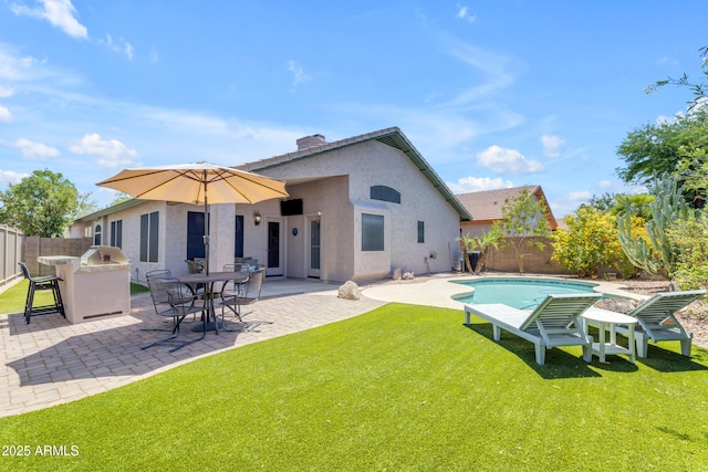 4301 E Abraham Ln, Phoenix, AZ 85050 - back of property featuring a fenced backyard, exterior kitchen, a patio, stucco siding, and a chimney