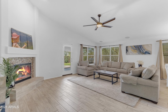 4301 E Abraham Ln, Phoenix, AZ 85050 - living room featuring ceiling fan, wood finished floors, a tiled fireplace, and high vaulted ceiling