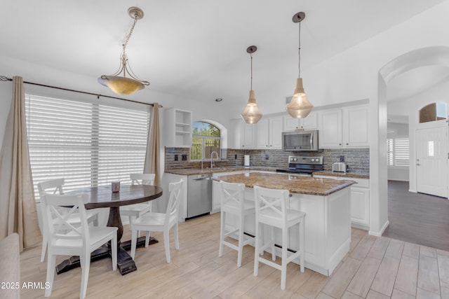 4301 E Abraham Ln, Phoenix, AZ 85050 - kitchen featuring stainless steel appliances, a center island, white cabinetry, and tasteful backsplash