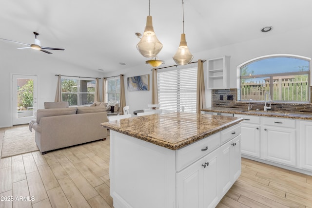 4301 E Abraham Ln, Phoenix, AZ 85050 - kitchen with a center island, light wood-type flooring, light stone counters, a ceiling fan, and hanging light fixtures