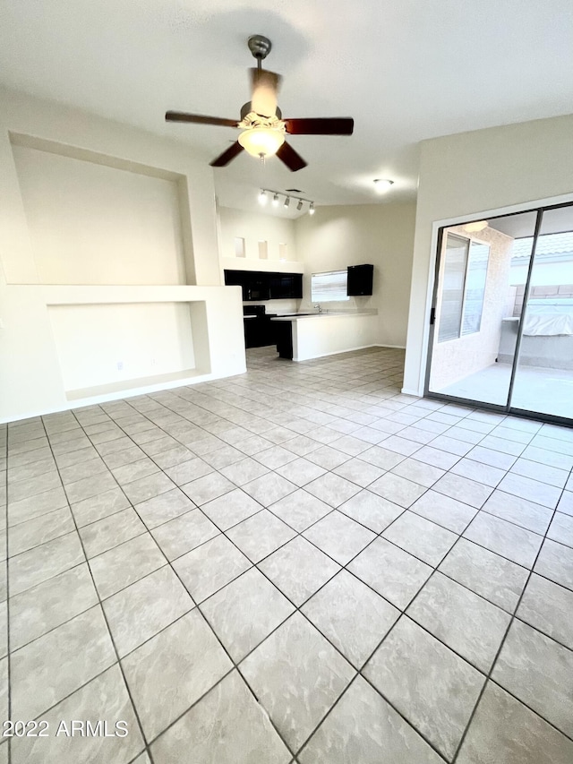 unfurnished living room featuring light tile patterned floors, rail lighting, and ceiling fan