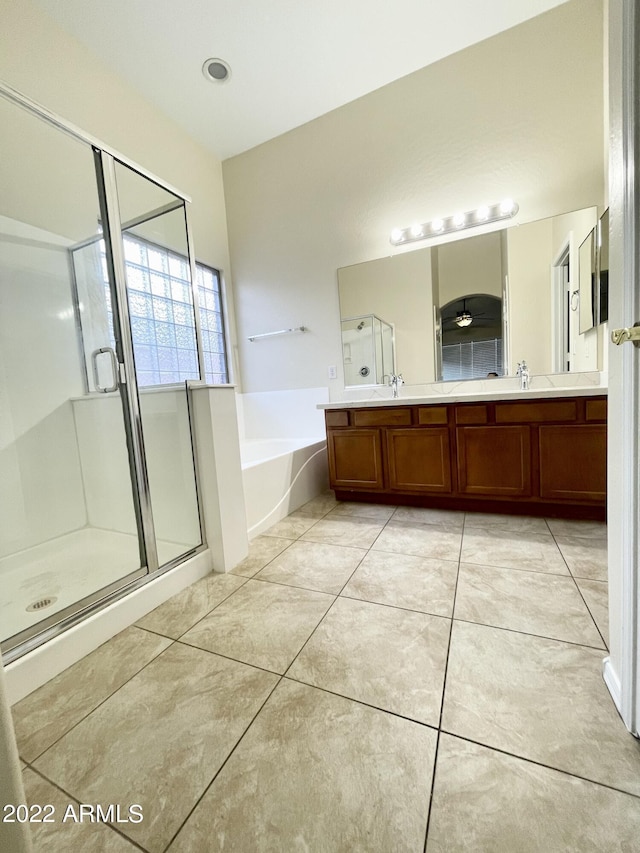 bathroom with tile patterned flooring, vanity, and plus walk in shower