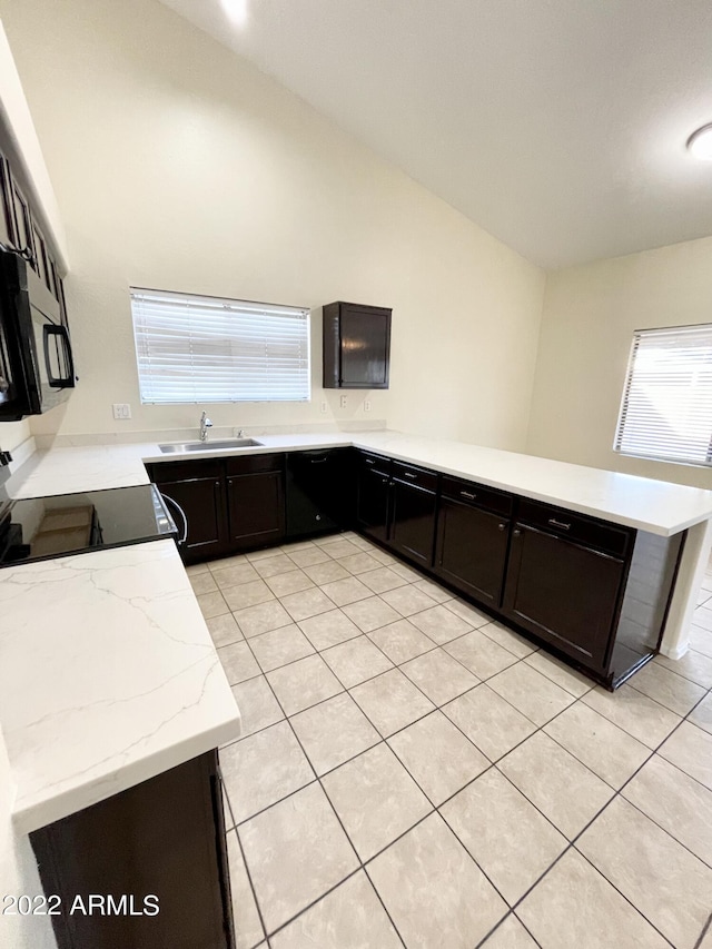 kitchen featuring lofted ceiling, electric range oven, sink, and kitchen peninsula