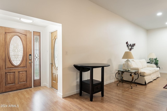 foyer entrance featuring lofted ceiling and light wood-type flooring